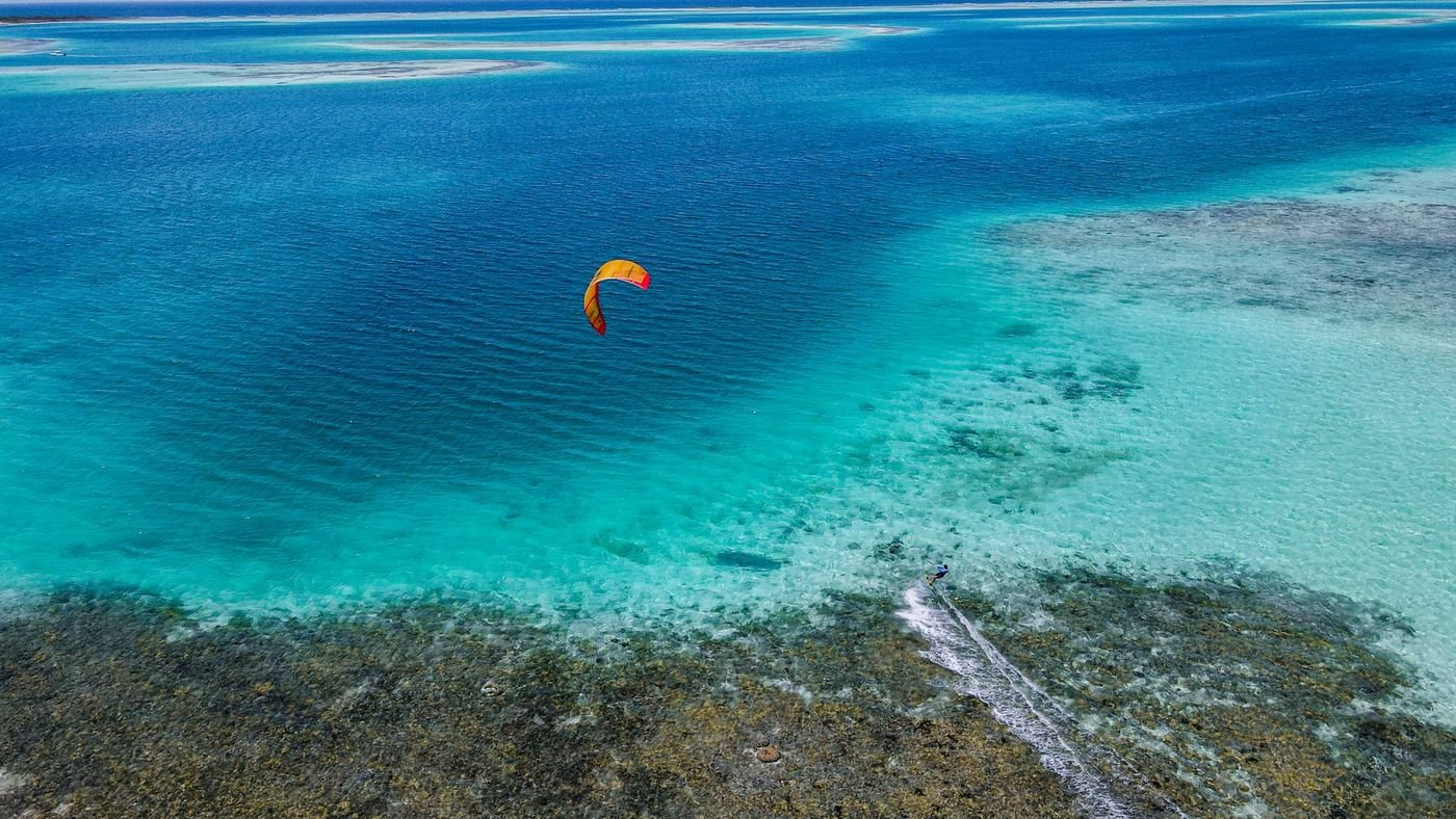 Un kitesurfeur sur un lagon turquoise